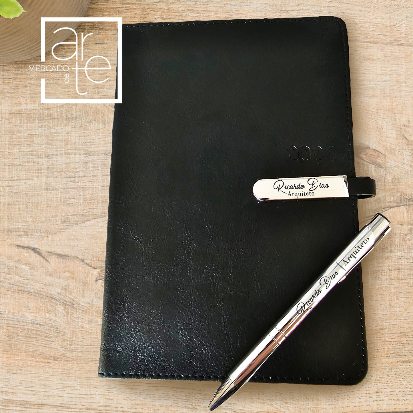 Agenda 2024 " Profissão " tamanho A5 com capa pele sintética e com fecho metalizado. Modelo super elegante para profissionais de qualquer área. Pode personalizar com texto que desejar. Conjunto agenda e caneta metalizada. Medida: 21x14,50cm.