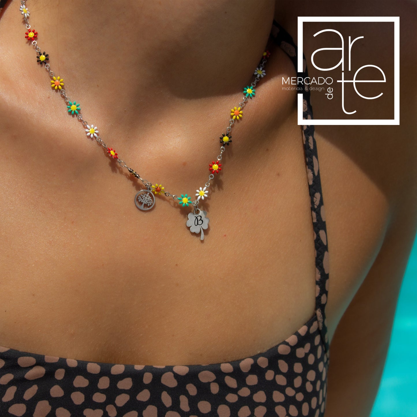 A combinar com o verão e com o bronze, este colar ficará perfeito em todos os looks deste verão! Fio " Flores " em aço inoxidável e esmalte com base prateada, com dois pendentes cheios de simbolismo: arvore da vida e trevo da sorte para colocar iniciais.