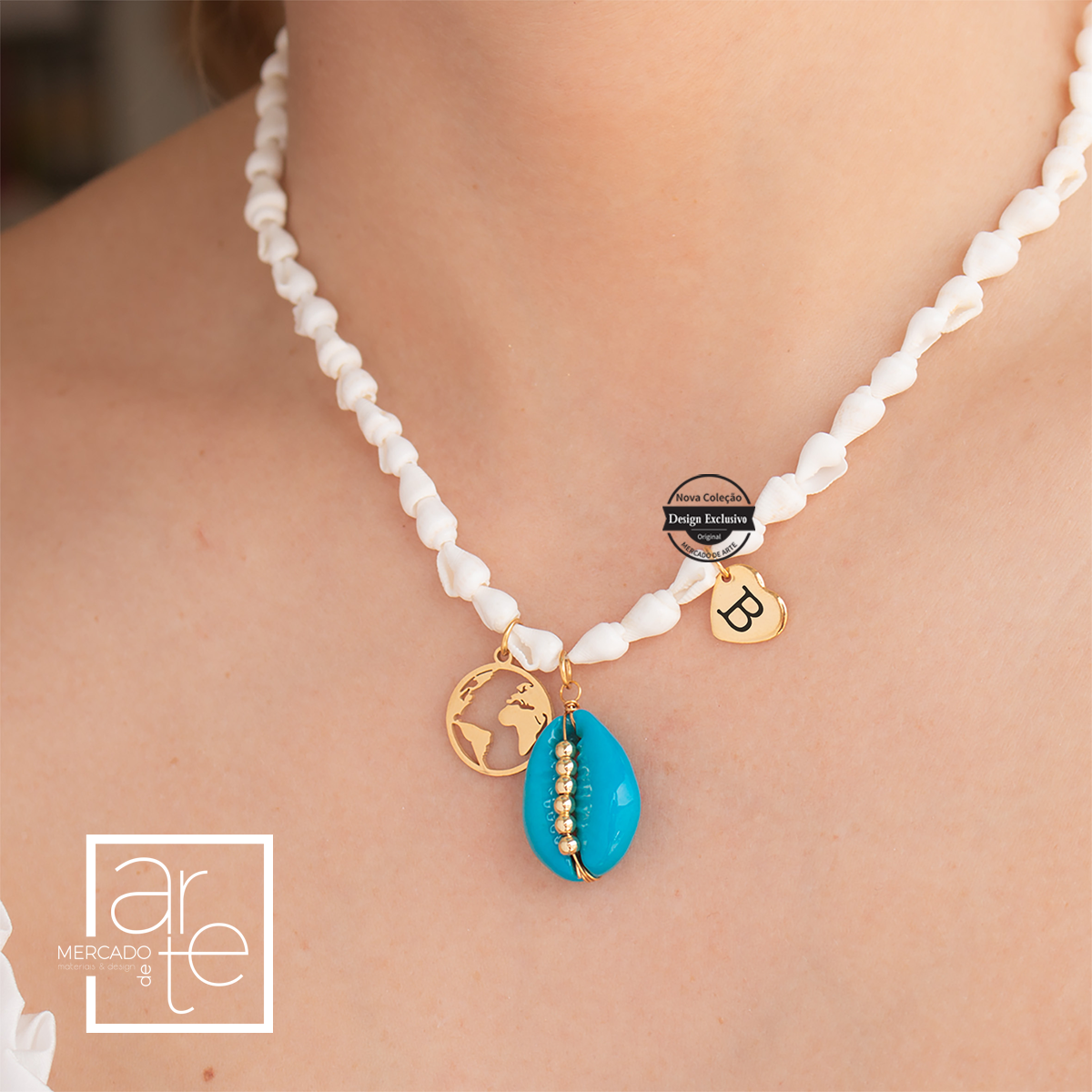 Fio em búzios brancos com pendente de búzio azul e mundo. Pode personalizar a medalhinha com a inicial que desejar.