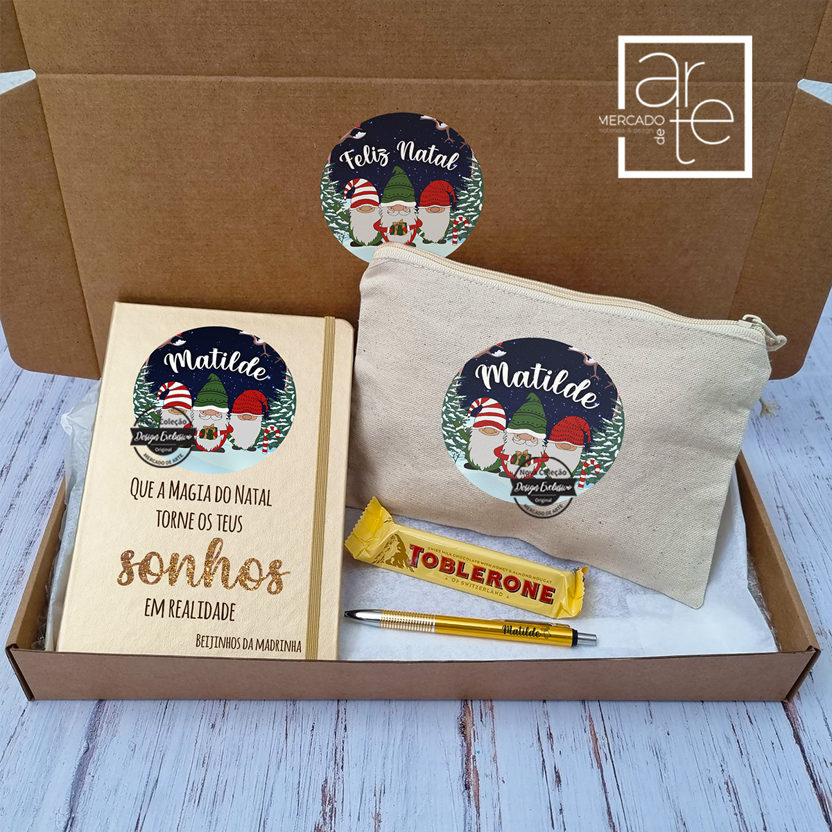 Kit da nova coleção Gnomos, super giro para presente de Natal!   Conjunto composto por:  Bloco A5 com folhas lisas metalizado, bolsa em tecido tipo linho, caneta metalizada e chocolate toblerone. Inclui caixa especial para oferta do conjunto. Autocolante da caixa não personalizável.  Pode personalizar com o texto que desejar e para a pessoa que desejar. Surpreenda com um presente personalizado por si!   REF: MA-NAT117